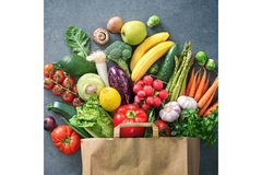 Image Assortment of fresh fruits and vegetables spilling from a paper grocery bag
